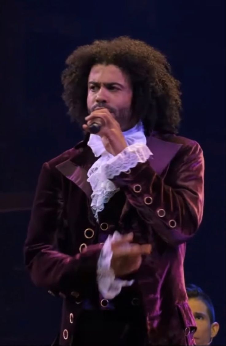 a man with an afro singing into a microphone