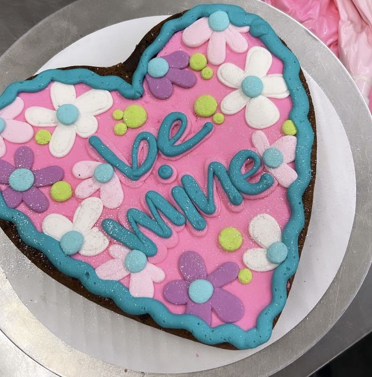 a heart shaped cake with the words be mine on it