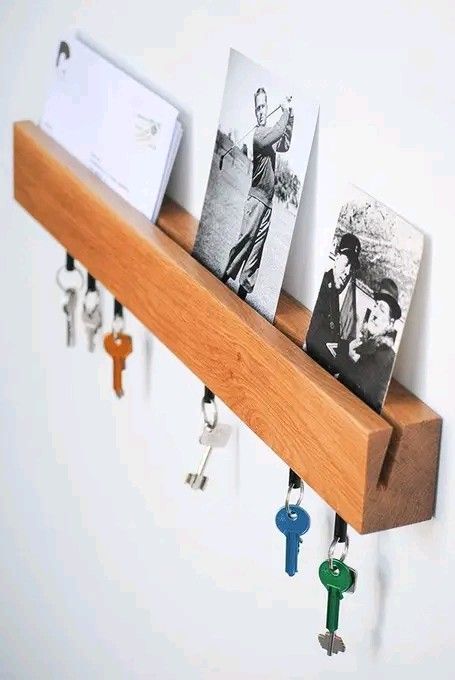 a wooden shelf with keys and photos hanging on it