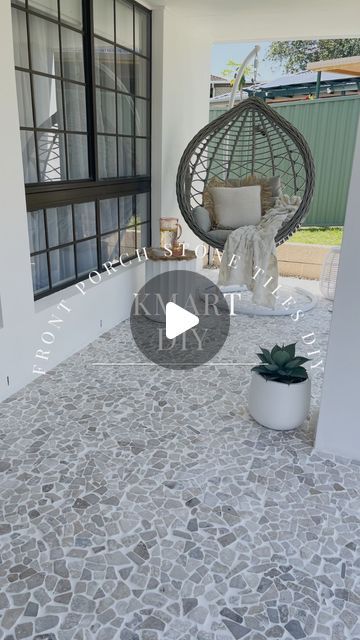 a patio with a hanging chair and potted plant