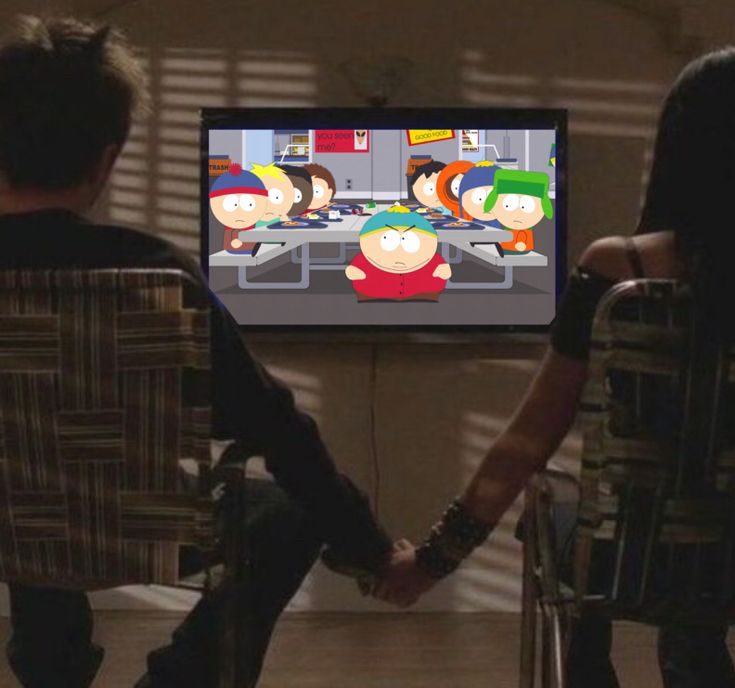 two people holding hands in front of a flat screen tv with cartoon characters on it