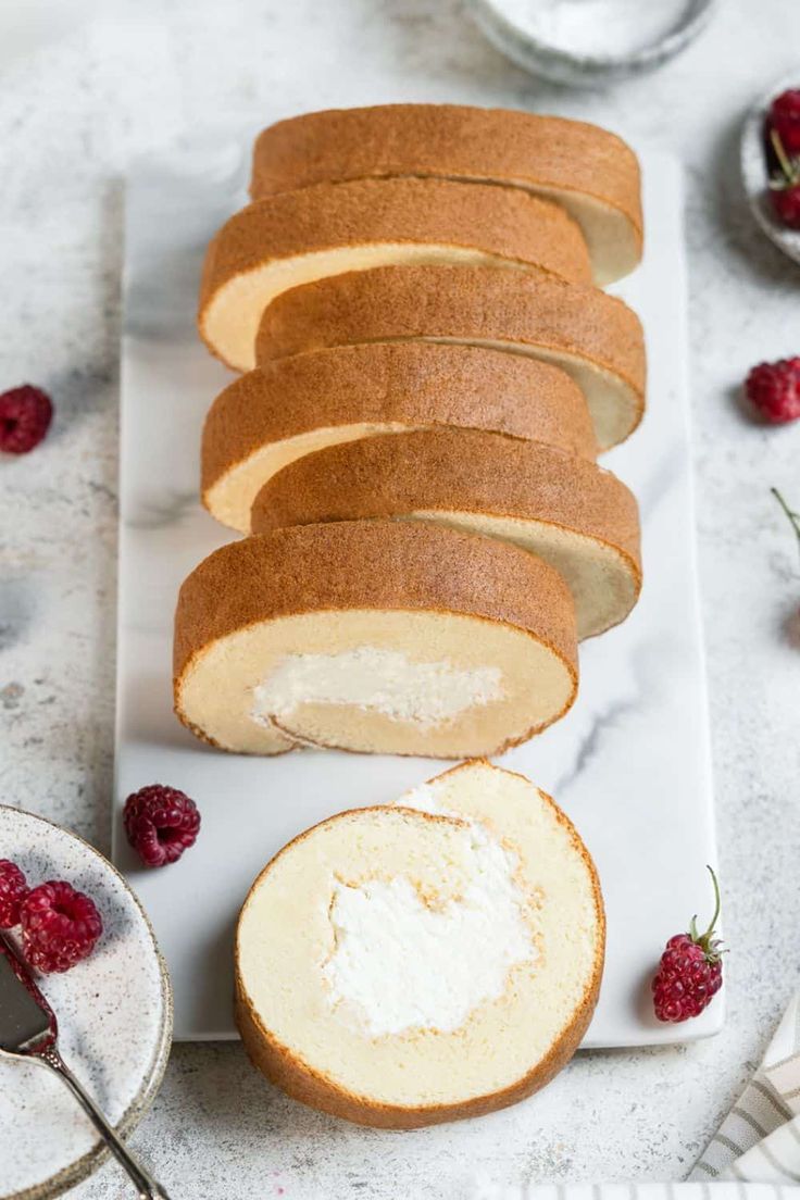 sliced loaf of pound cake with raspberries on the side