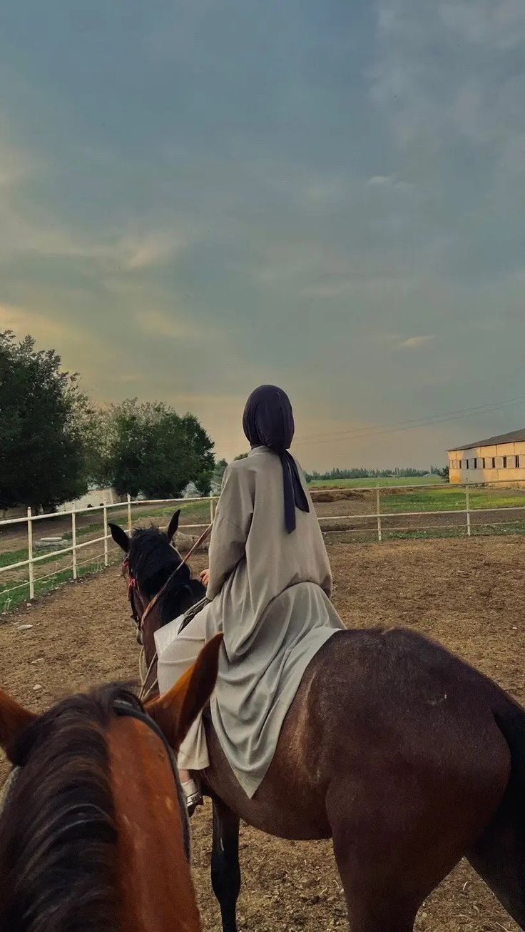 a woman riding on the back of a brown horse