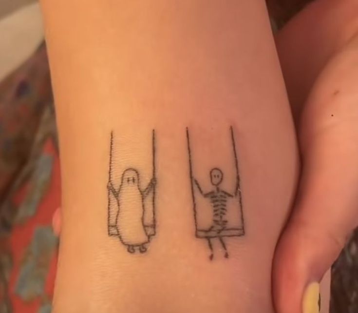 a person with a small tattoo on their foot that has a penguin and skeleton drawn on it