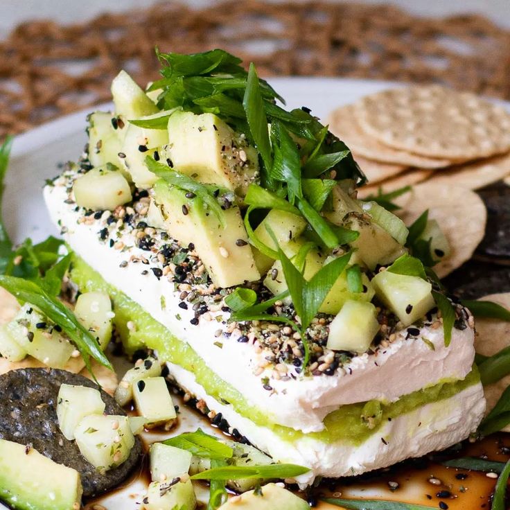 a white plate topped with food next to crackers