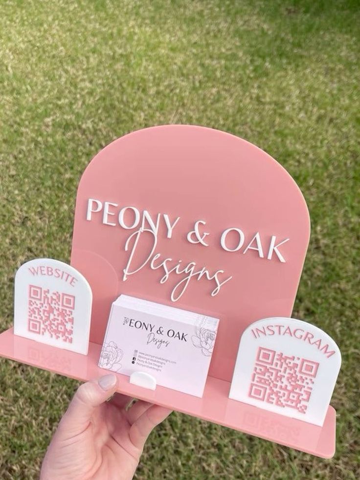 a person holding up a pink sign with qr code on the front and side