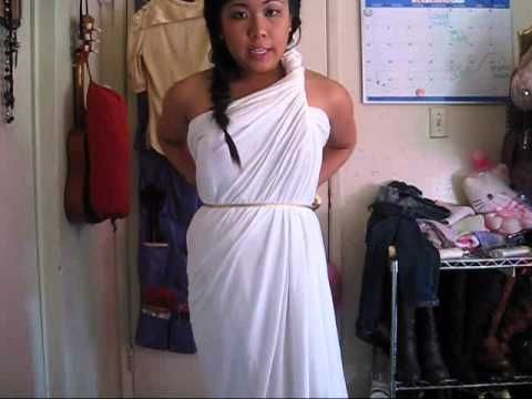 a woman in a white dress standing next to a closet with clothes hanging on the wall