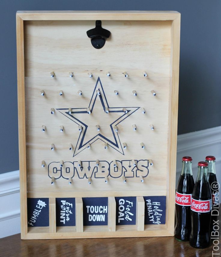 a wooden sign with six bottles of soda in front of it and the word cowboys written on it