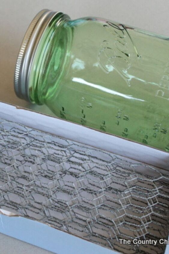 a green mason jar sitting on top of a piece of paper next to a ruler