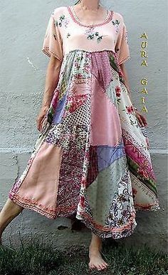 a woman standing in front of a wall wearing a dress made out of different fabrics