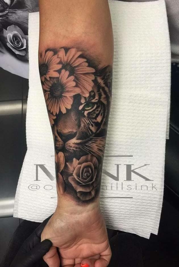 a woman's arm with a tiger and flowers on it