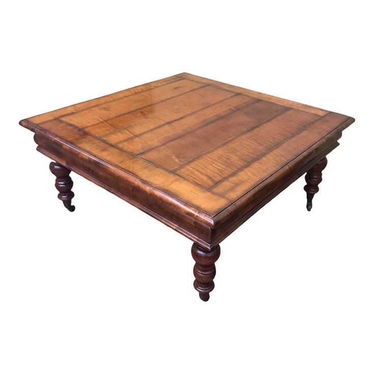 a square wooden table with turned legs on an isolated white background for use as a coffee table