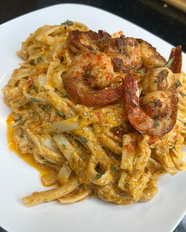 a white plate topped with pasta and shrimp