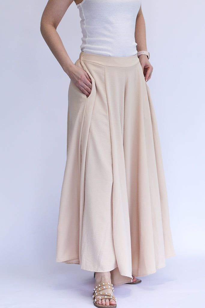 Be the talk of every room with our Keep it Glowing - Woven Wide Leg Pants! These champagne, satin pants are beyond gorgeous. They give the illusion of a skirt, but bring the comfort of pants. This item has a high waist, elastic waist band, and pockets. We love these so much because you can throw on a blouse to dress them up, or a tank to dress them down. You can wear these for any occasion and be the most stylish gal in the room! - Champagne colored woven wide leg pants - High waist - Elastic wa Elegant High Waist Beige Culottes, Elegant Beige Wide Leg Pants With Elastic Waistband, Chic Full-length Culottes With Elastic Waistband, Spring Flowy Skirt Bottoms, Beige Full-length Bottoms With Elastic Waistband, Full Length Beige Bottoms With Elastic Waistband, Beige High Waist Harem Pants With Elastic Waistband, High Waist Elastic Maxi Skirt, Spring Wide Leg Bottoms With Waistband