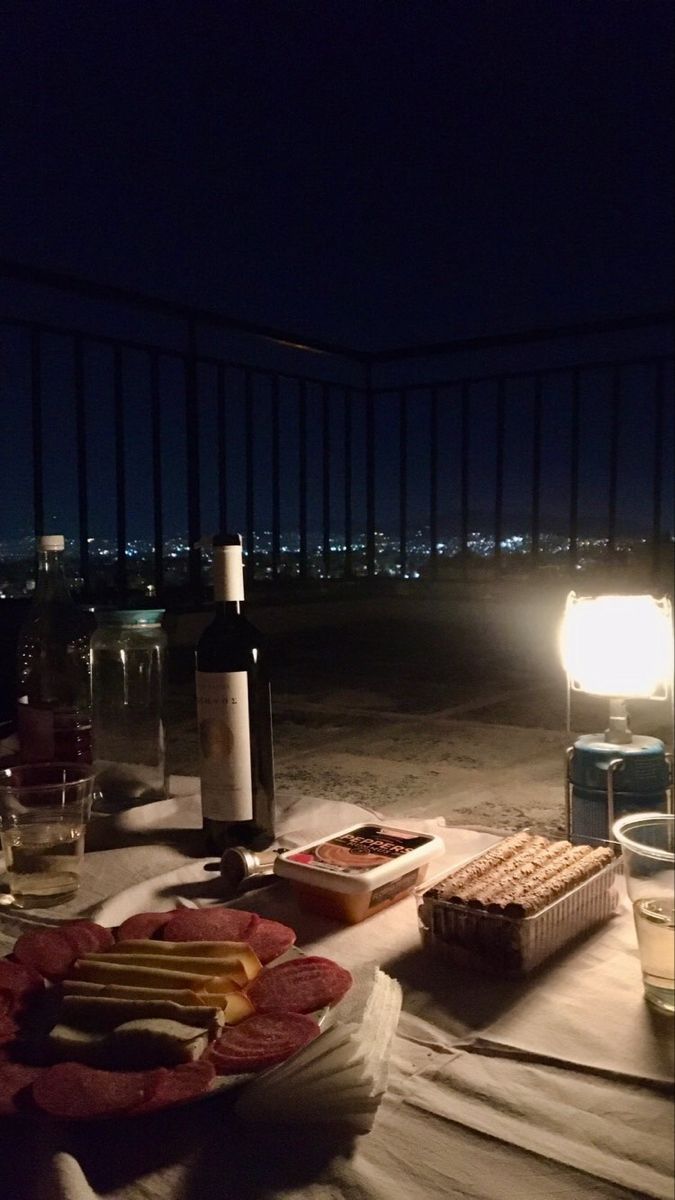 a table with food and wine on it at night