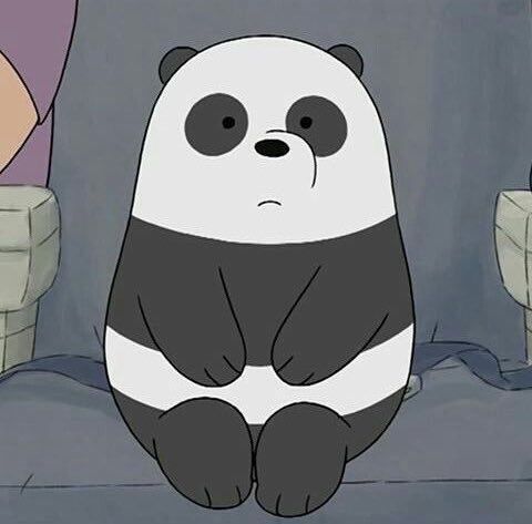 a panda bear sitting on top of a bed