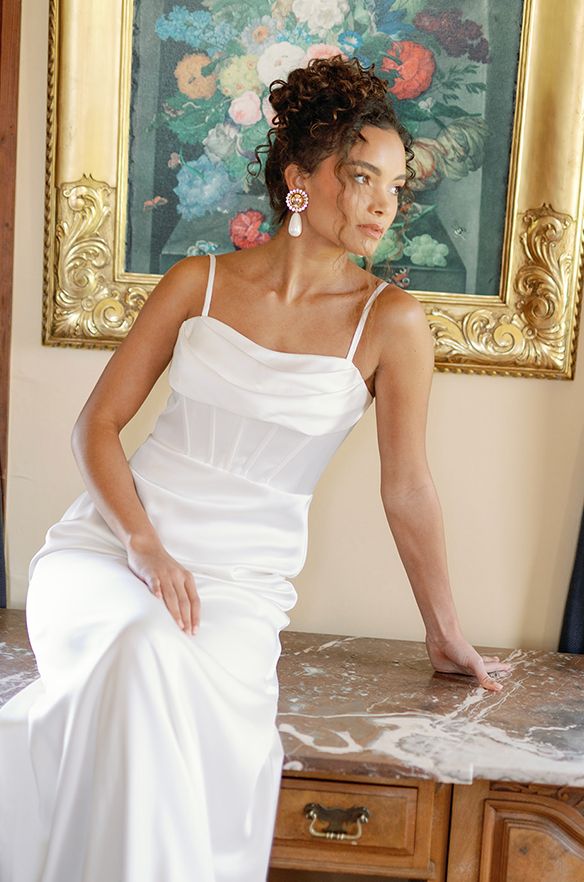 a woman in a white dress sitting on a table