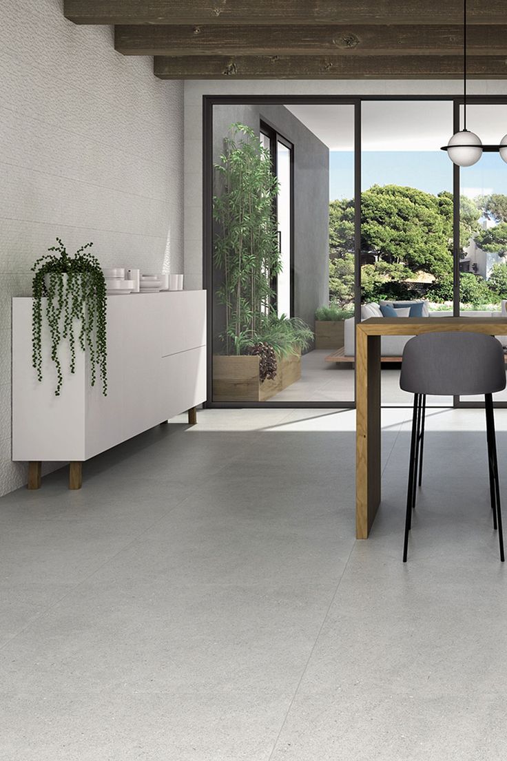 a dining room table with chairs and plants on it