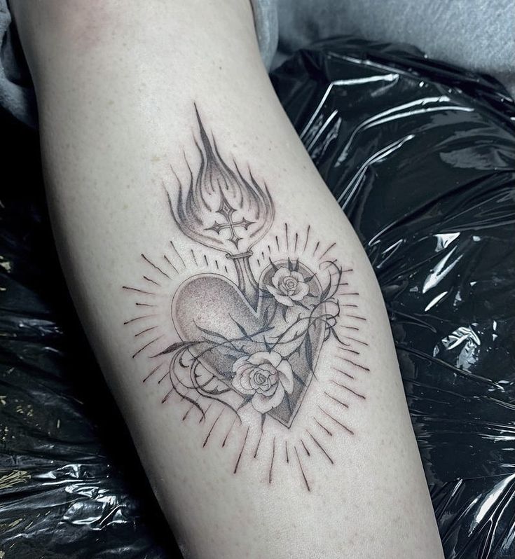 a tattoo on the leg of a person with a heart and two candles in it