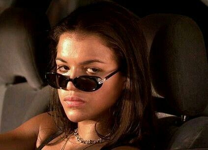 a woman sitting in the back seat of a car wearing sunglasses