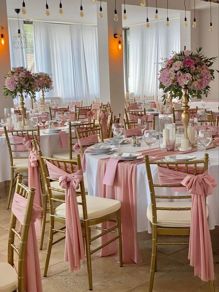 a room filled with lots of tables covered in pink and white cloths