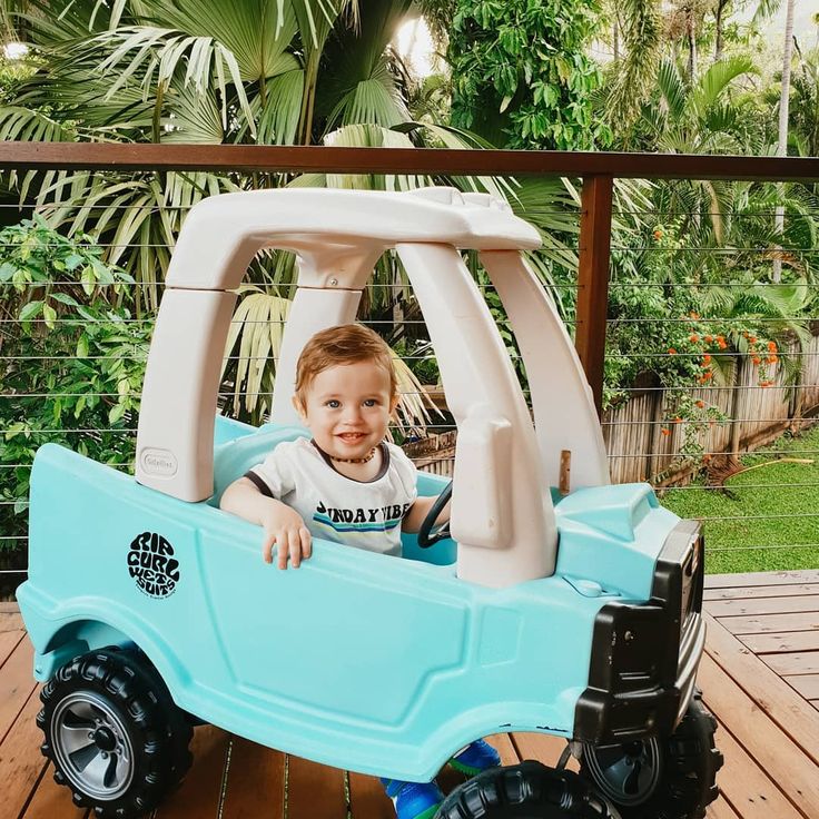 a little boy sitting in a toy truck