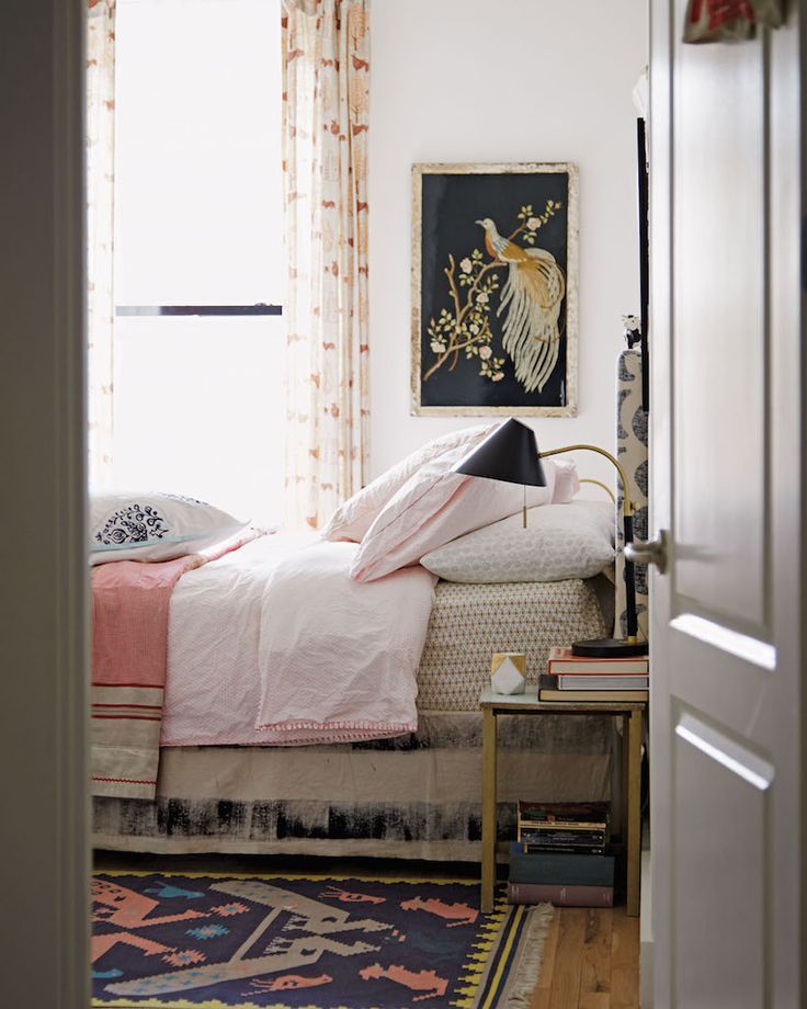 a bed room with a neatly made bed next to a window