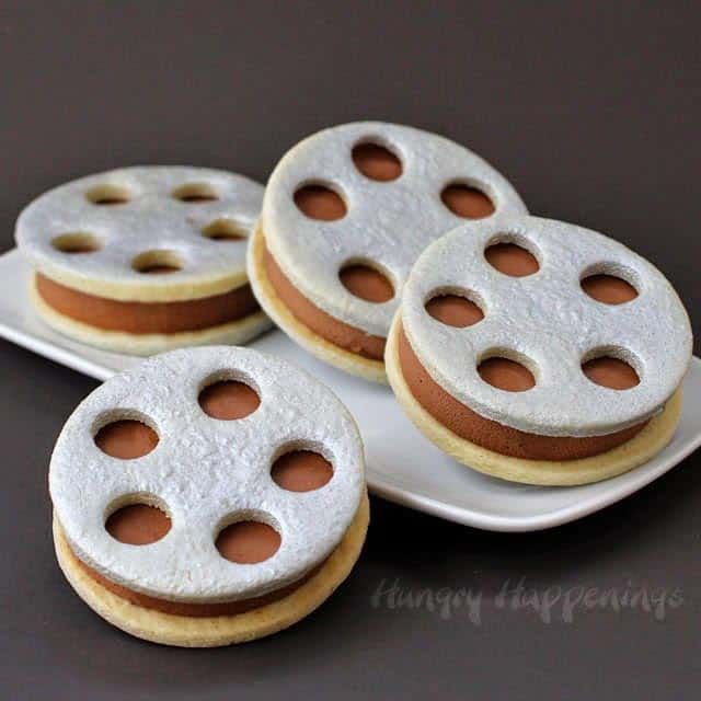 four cookies with holes on them sitting on a plate