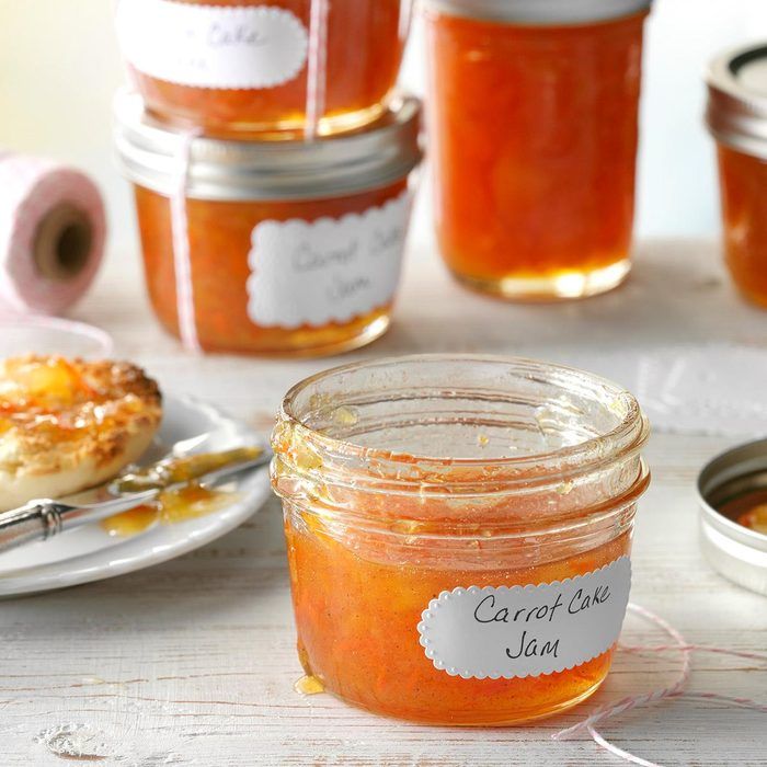 there are several jars of jam on the table with plates and spoons next to them