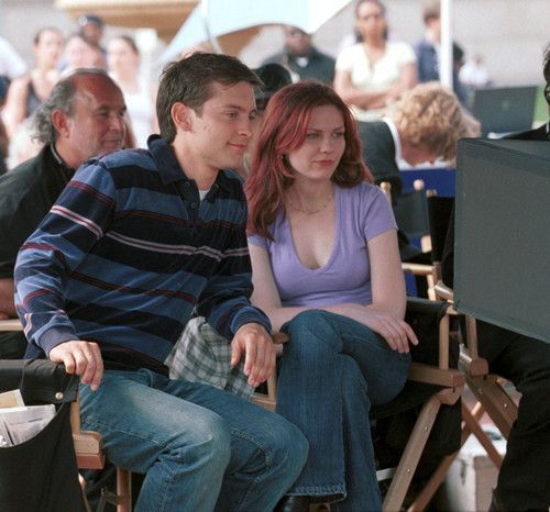 a man and woman sitting next to each other in front of a tv screen on a chair