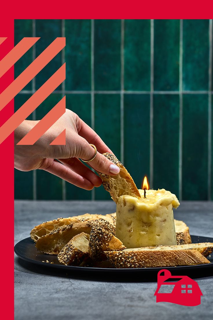 a person lighting a candle on some bread