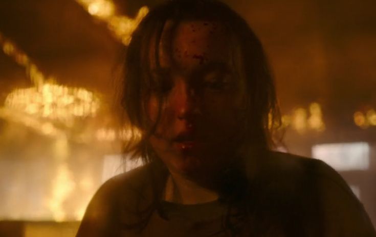 a woman with blood all over her face standing in front of a window at night