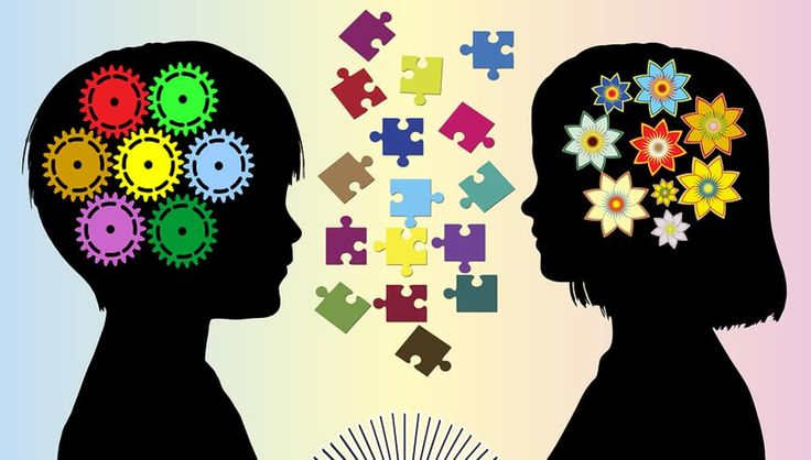 two silhouettes facing each other with colorful puzzle pieces in the shape of their heads