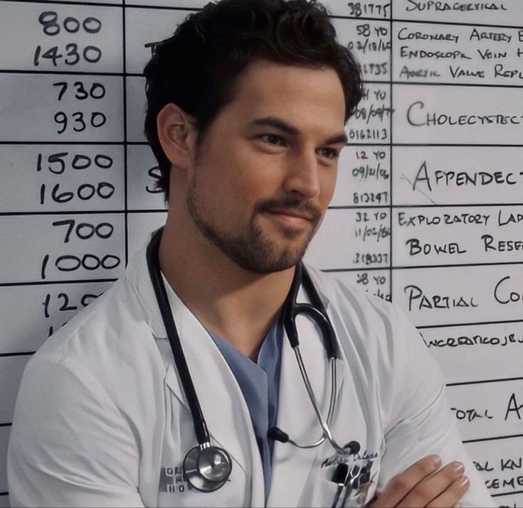 a man with a stethoscope standing in front of a wall that has writing on it