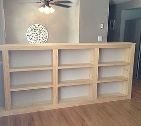 an empty room with a ceiling fan and bookcases on the floor in front of it