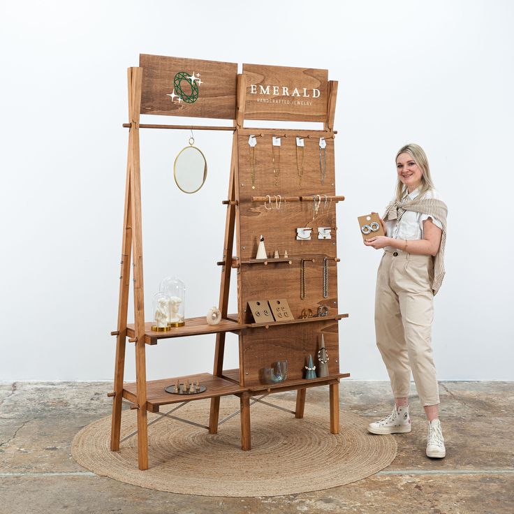 a woman standing next to a wooden display case