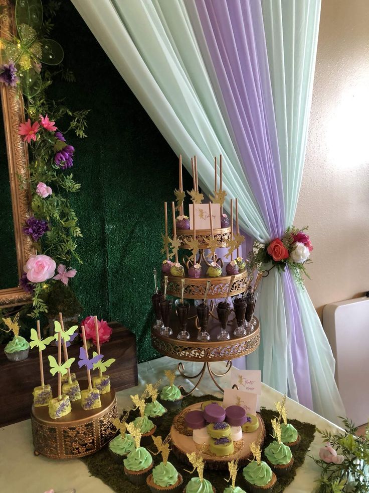 a table topped with cakes and cupcakes covered in frosting