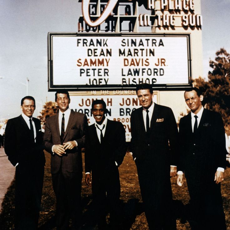 four men in suits are standing next to a sign that says frank santara dean martin sammy davis jr peter lawford joey elsie