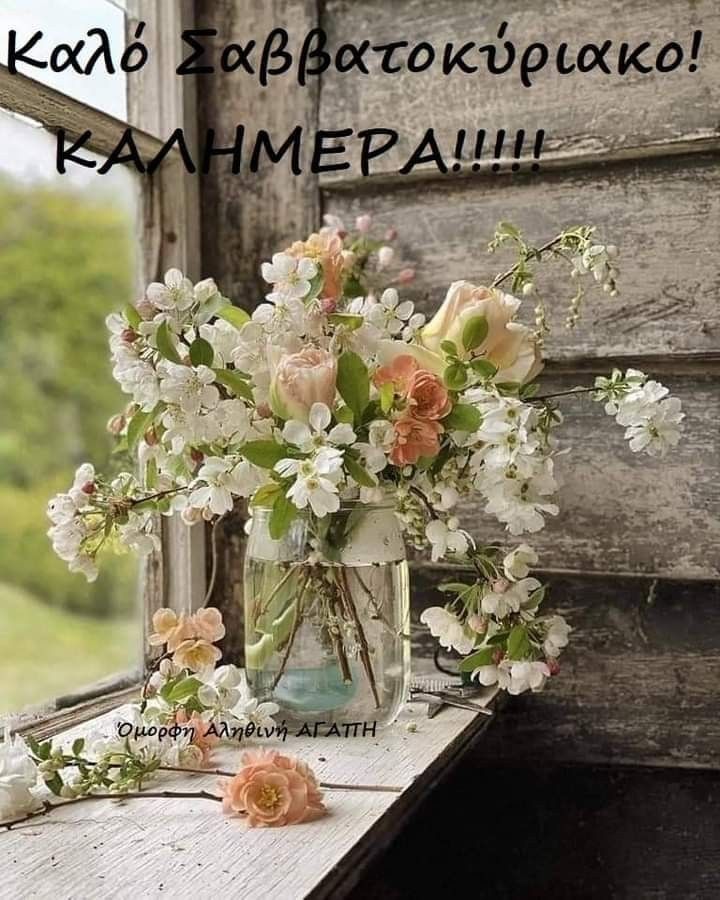 a vase filled with lots of flowers sitting on top of a table next to a window