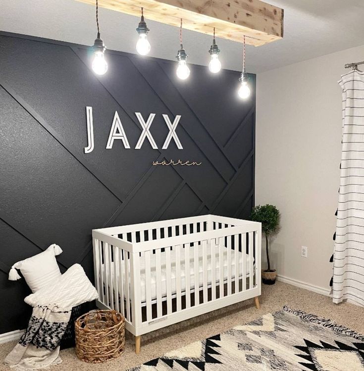 a baby's room decorated in black and white with the name ajax on the wall