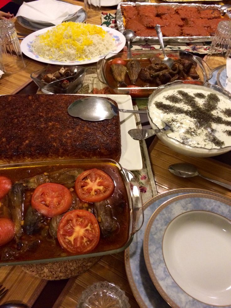 a table filled with lots of food on top of plates and silver wares,