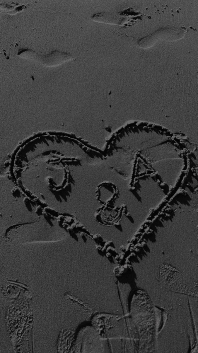 a heart drawn in the sand with an i love you written on it's side