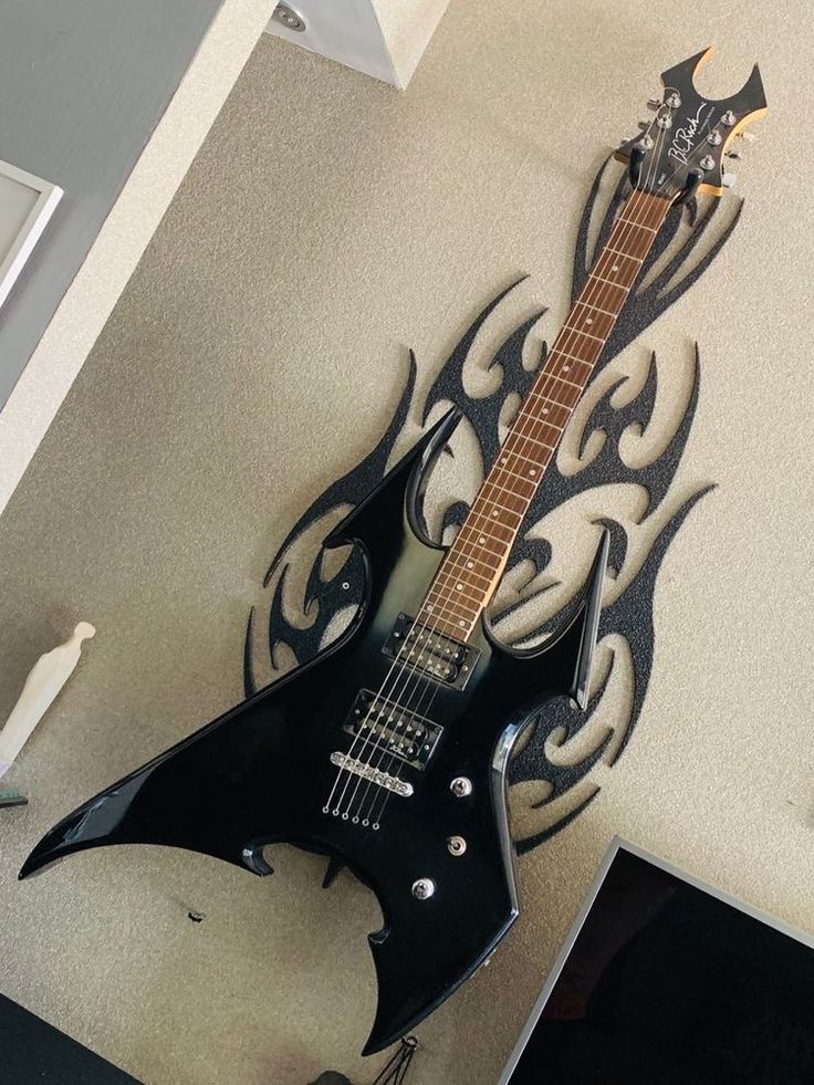 an electric guitar is mounted to the wall with intricate designs on it's body