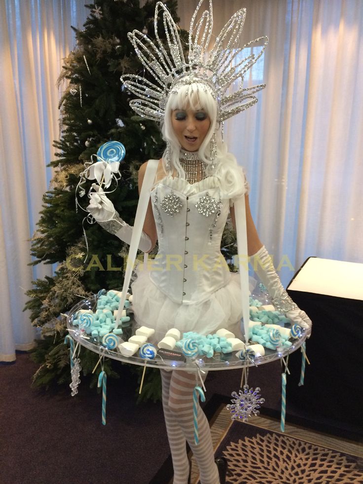 a woman dressed up as a fairy holding a tray with cupcakes on it