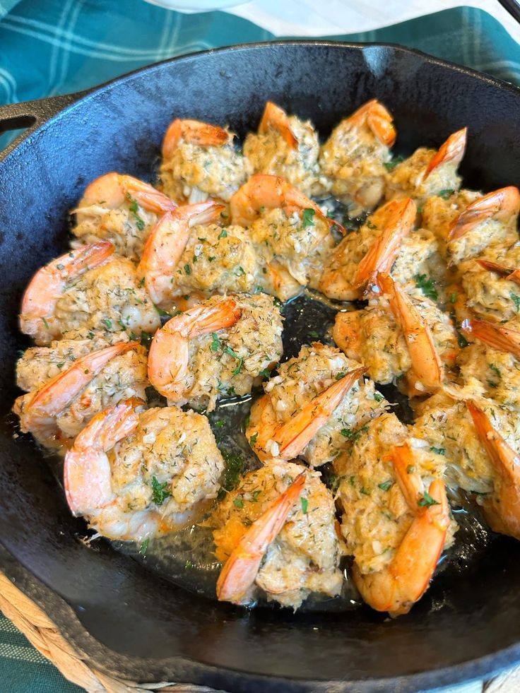 shrimp and rice cooking in a skillet on top of a blue cloth covered table