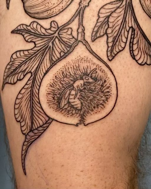 a tattoo on the back of a man's leg with fruit and leaves around it