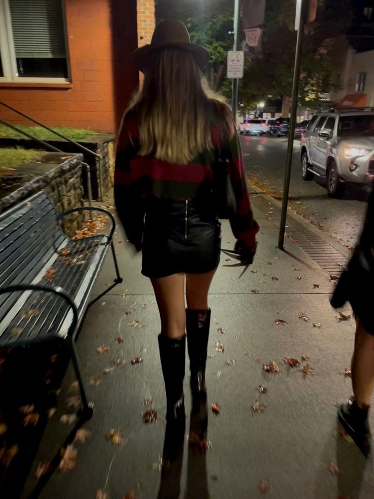 a woman walking down the street in thigh high boots