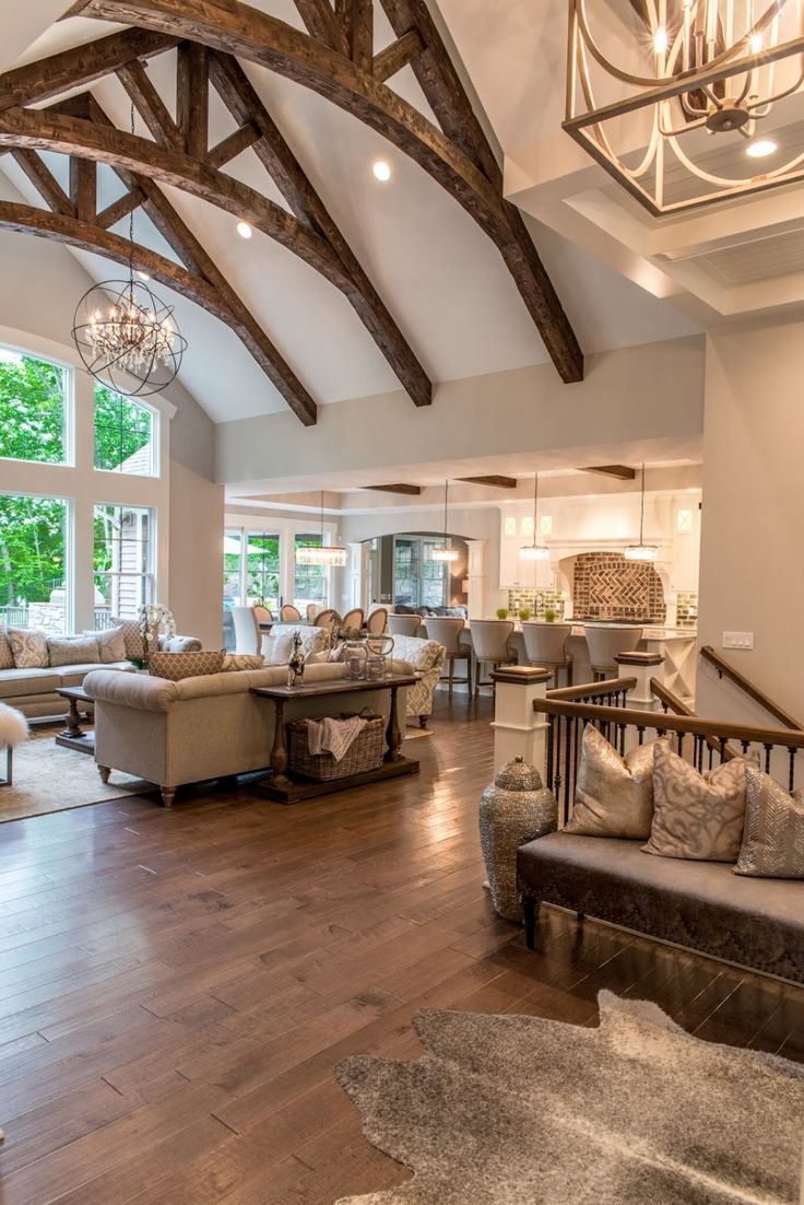 a living room filled with lots of furniture and a chandelier hanging from the ceiling