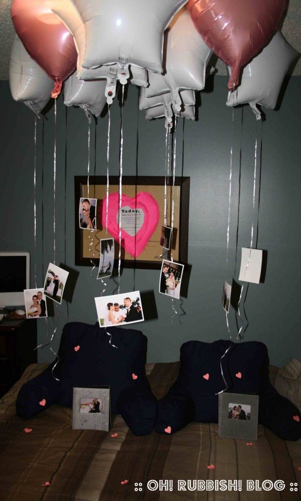 balloons are hanging from the ceiling above a bed with pictures and photos attached to it