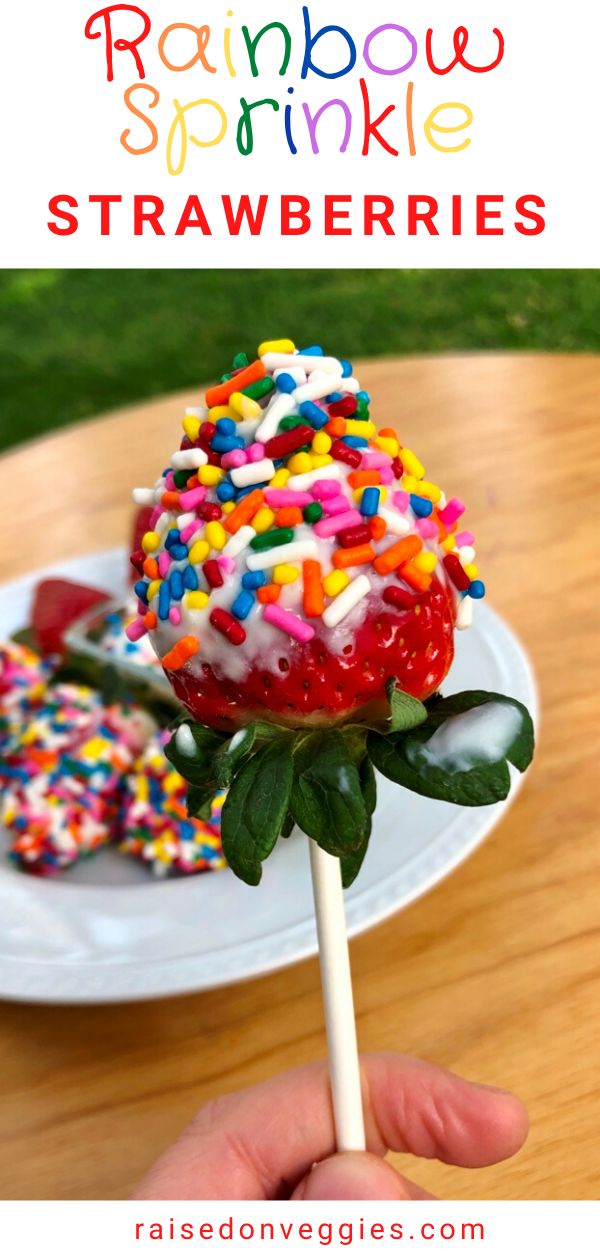 rainbow sprinkle strawberries on a stick in front of a plate with donuts